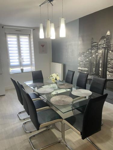 a dining room with a glass table and black chairs at Beautiful apartment F4 Suite Manon in Joeuf