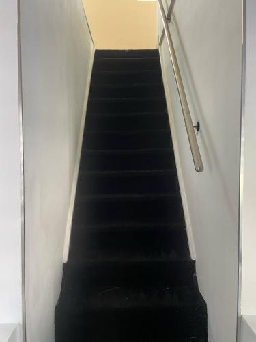 a stair case with black stairs and a railing at Beautiful apartment F4 Suite Manon in Joeuf