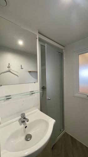 une salle de bain avec un lavabo blanc et une douche dans l'établissement Comfortable mobile home - Ck248 Les Charmettes Siblu, aux Mathes