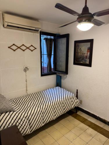 a bed in a room with a ceiling fan at Casa Bonita Barrio Sur in Santa Fe