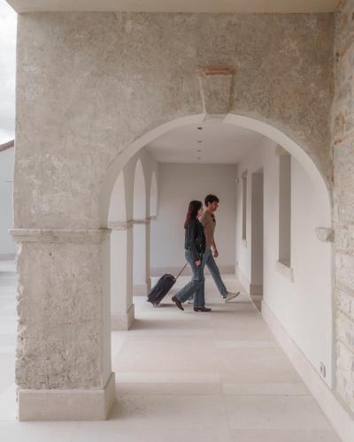 two people walking through an archway with their luggage at Agriturismo Prà dell'Ort - Wishing Wellness in Valdobbiadene