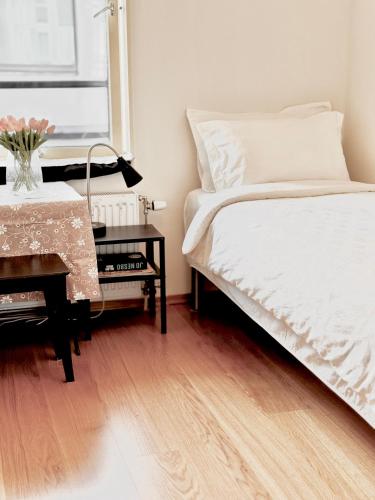 a bedroom with a bed and a table with a desk at Room Available at City in Oslo
