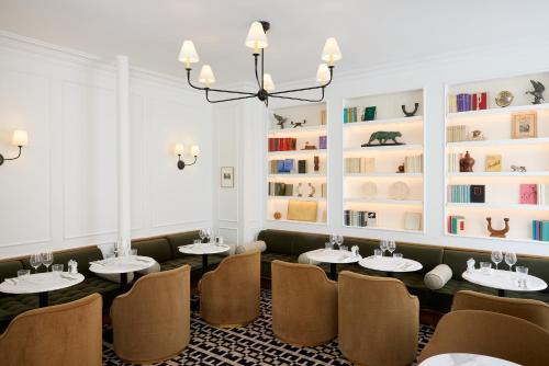a dining room with tables and chairs and bookshelves at Hôtel Noucha in Paris