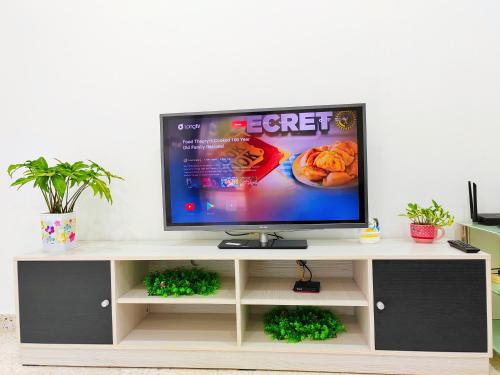 a flat screen tv sitting on top of a tv stand at Ipoh Garden Sunway Guesthouse in Ipoh