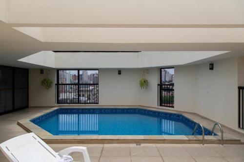 a large swimming pool with a white chair at Hotel Bienal Ibirapuera UH310 in Sao Paulo