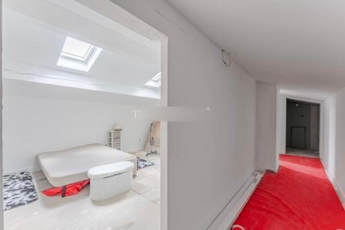 une pièce blanche avec un banc et un tapis rouge dans l'établissement Maison clôturée, piscine privée, à Saint-Pierre-de-Bat