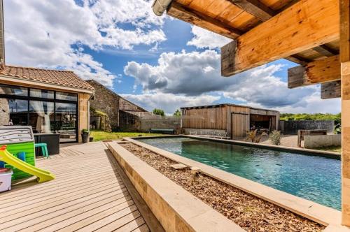 une cour arrière avec une piscine et une terrasse en bois dans l'établissement Maison clôturée, piscine privée, à Saint-Pierre-de-Bat