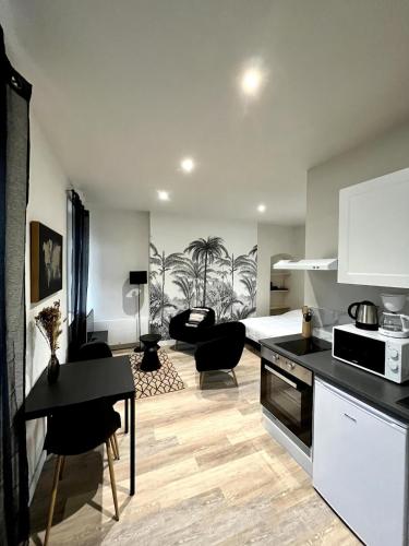 Il comprend une cuisine et un salon avec un lit et une table. dans l'établissement CASA Palmera, à Cholet