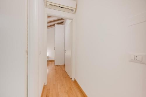 a hallway with white walls and a wooden floor at Davide Flat - 15 min from Venice & Free Parking in Mira