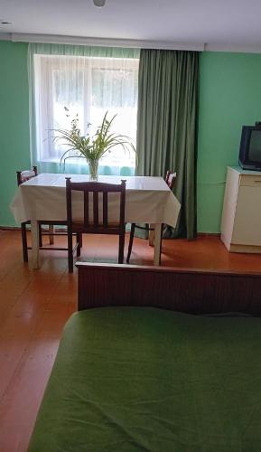 a table and chairs in a room with a window at Еко дом с верандой с видом на горы in Borjomi