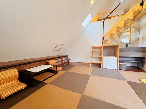 a room with a staircase and a table and benches at Hakuba Sun Valley Hotel in Hakuba
