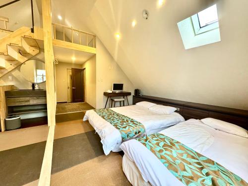 two beds in a room with a loft at Hakuba Sun Valley Hotel in Hakuba