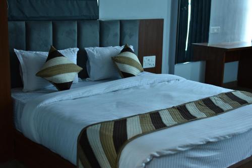 a bedroom with a large bed with white sheets and pillows at pushkar mountain valley in Pushkar