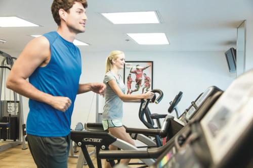a man and a woman on a treadmill in a gym at Riu Plaza Miami Beach in Miami Beach