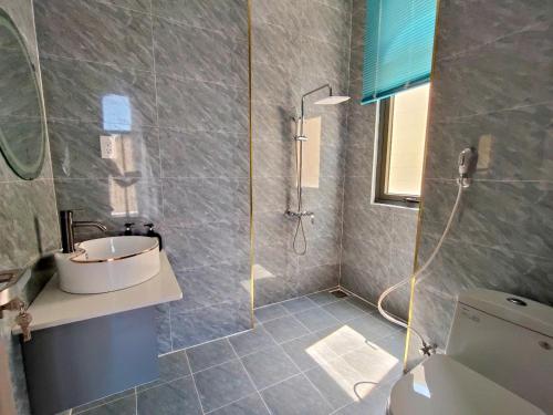 a bathroom with a shower and a sink and a toilet at Happy Stay Resort Wonderland Ho Tram in Xuyên Mộc