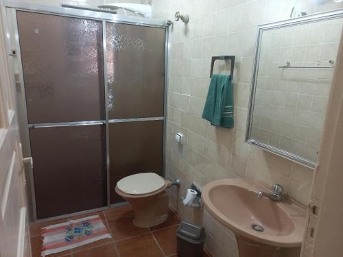 ein Badezimmer mit Dusche, Toilette und Waschbecken in der Unterkunft Casa para temporada in Praia Grande