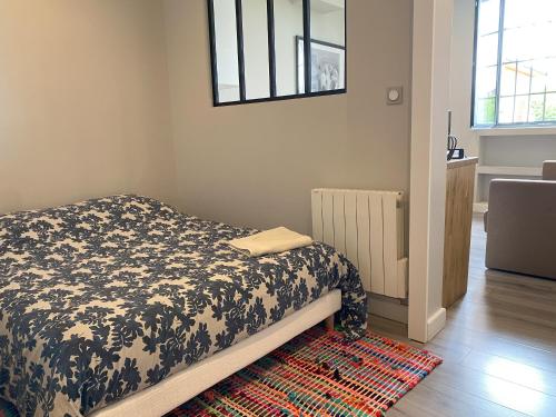 a bedroom with a bed with a black and white blanket at Appartements de la ferme du Brocey in Crolles