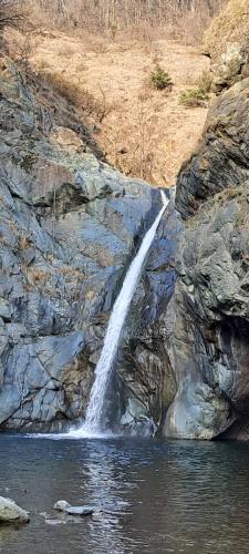 a waterfall on the side of a rocky cliff at Babi la tappa di novaretto in Caprie