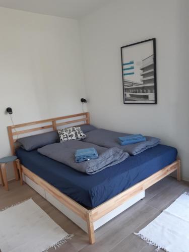 a bed in a bedroom with blue sheets and a picture at Ihre Auszeit am See in Lychen