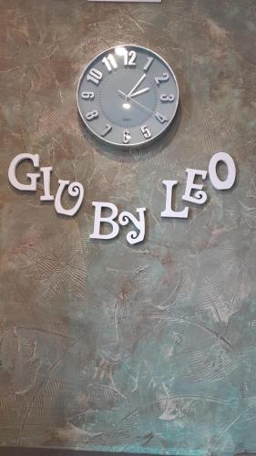 a clock sitting on top of a sign at GiuByLeo in Rome