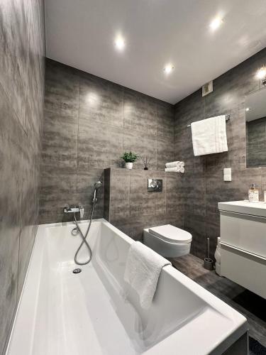 a bathroom with a white tub and a toilet at Apartment 19 - by Aquapark Reda in Reda