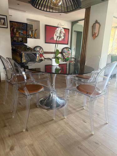 une salle à manger avec une table et des chaises en verre dans l'établissement LOFT - AVIGNON PROCHE REMPART, à Avignon