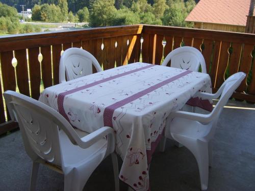une table avec deux chaises et une table avec un tissu de table dans l'établissement COUP de COEUR - bord et vue lac Gérardmer, à Gérardmer