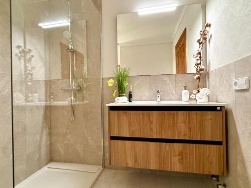 ein Badezimmer mit Waschbecken und Dusche mit Spiegel in der Unterkunft Villa Gotmar in Port de Pollença