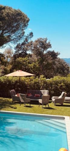 - une piscine avec des chaises et un parasol à côté dans l'établissement VillaGassin 403, à Saint-Tropez