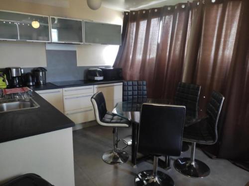 une cuisine avec une table et des chaises dans l'établissement Ajaccio JACUZZI VUE MER ET MONTAGNES 300 METRES DES PLAGESS, à La Celle-sous-Gouzon