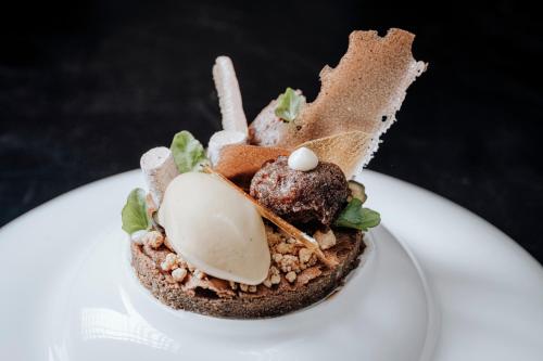 a dessert on a white plate on a table at AlpinSpa zur Post Apartment - Bergbahn im Sommer 2025 inklusive in Bad Gastein
