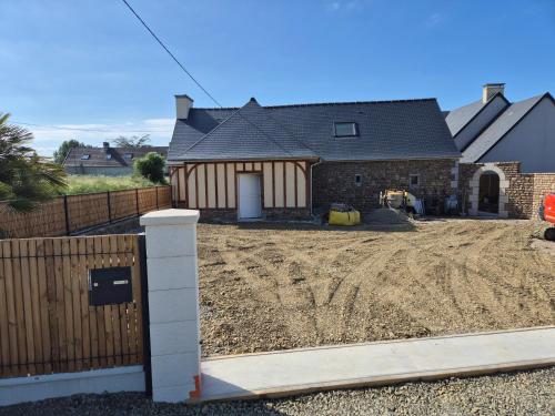 une maison en construction avec une clôture devant elle dans l'établissement Gites du havre de la venlee, à La Celle-sous-Gouzon