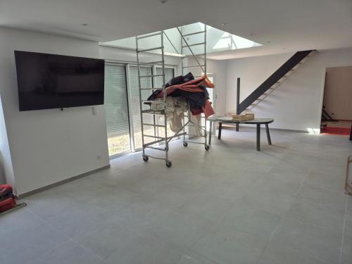 - un salon avec une télévision et un escalier dans l'établissement Gites du havre de la venlee, à La Celle-sous-Gouzon