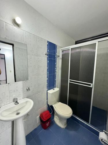 a bathroom with a toilet and a sink and a shower at Hotel San Pedro in Neiva