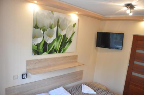 ein Zimmer mit einem Gemälde von weißen Tulpen an der Wand in der Unterkunft Hotel Mis in Salzberg