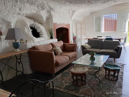 a living room with a couch and a fireplace at Maison troglodytique au coeur des Châteaux de la Loire - Le Cerisier Perché in Luynes