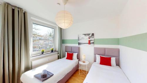 two beds in a small room with a window at Berner Bude 5, 3SZ, 6P, TV, Wlan in Hamburg