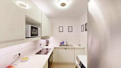 a white kitchen with a sink and a microwave at Berner Bude 5, 3SZ, 6P, TV, Wlan in Hamburg