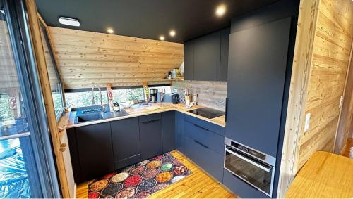 une petite cuisine avec un évier et une cuisinière dans l'établissement Le 36 Chalet 6 pers Le Mont-Dore Sauna Ski Hiking, à Mont-Dore