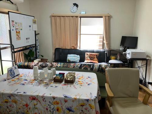 a living room with a table and a couch at ゆずハウス in Chofu