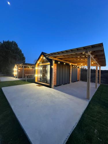 a modern house with a pavilion at night at Siedlisko Rawka in Doleck