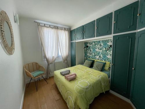 une chambre avec un lit avec des armoires vertes et une chaise dans l'établissement Appartement Vasil - proche de Paris, à Villemomble