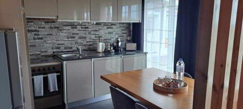 a kitchen with white cabinets and a wooden table at 3BL Retreat - Escape & Poolparty in Praia da Vitória