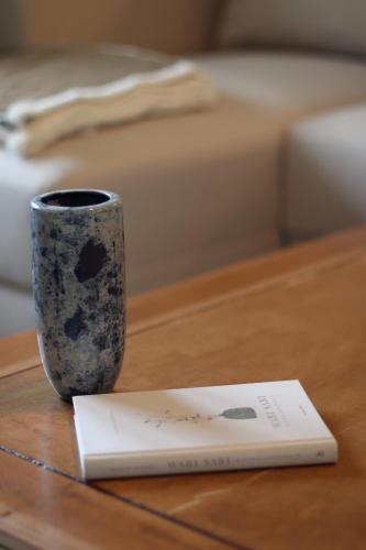 a vase sitting on a table next to a book at Lawendowy Raj in Pilchowice