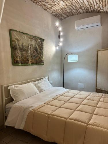 a bedroom with a bed with a painting on the wall at 17 per 2 in Martina Franca