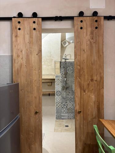a wooden door in a kitchen with a shower at 17 per 2 in Martina Franca