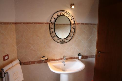 La salle de bains est pourvue d'un lavabo et d'un miroir mural. dans l'établissement Country House B&B Antica Dimora Del Sole, à Camerota