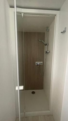 une douche avec une porte vitrée dans une salle de bain dans l'établissement Mobilhome Amira 40m2 - Cc781 Les Charmettes 4 stars, aux Mathes