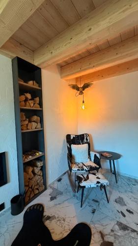 a living room with a chair and a table at Maso K - Il Gufo Dorato in Folgaria