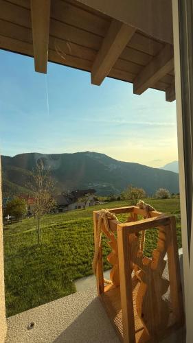 a balcony with a view of a field and mountains at Maso K - Il Gufo Dorato in Folgaria